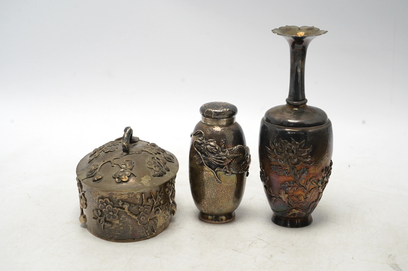 An early 20th century Japanese oval white metal box and associated? cover, 10.2cm, together with a similar posy vase, jar without cover and three mounted clothes brushes. Condition - fair to poor